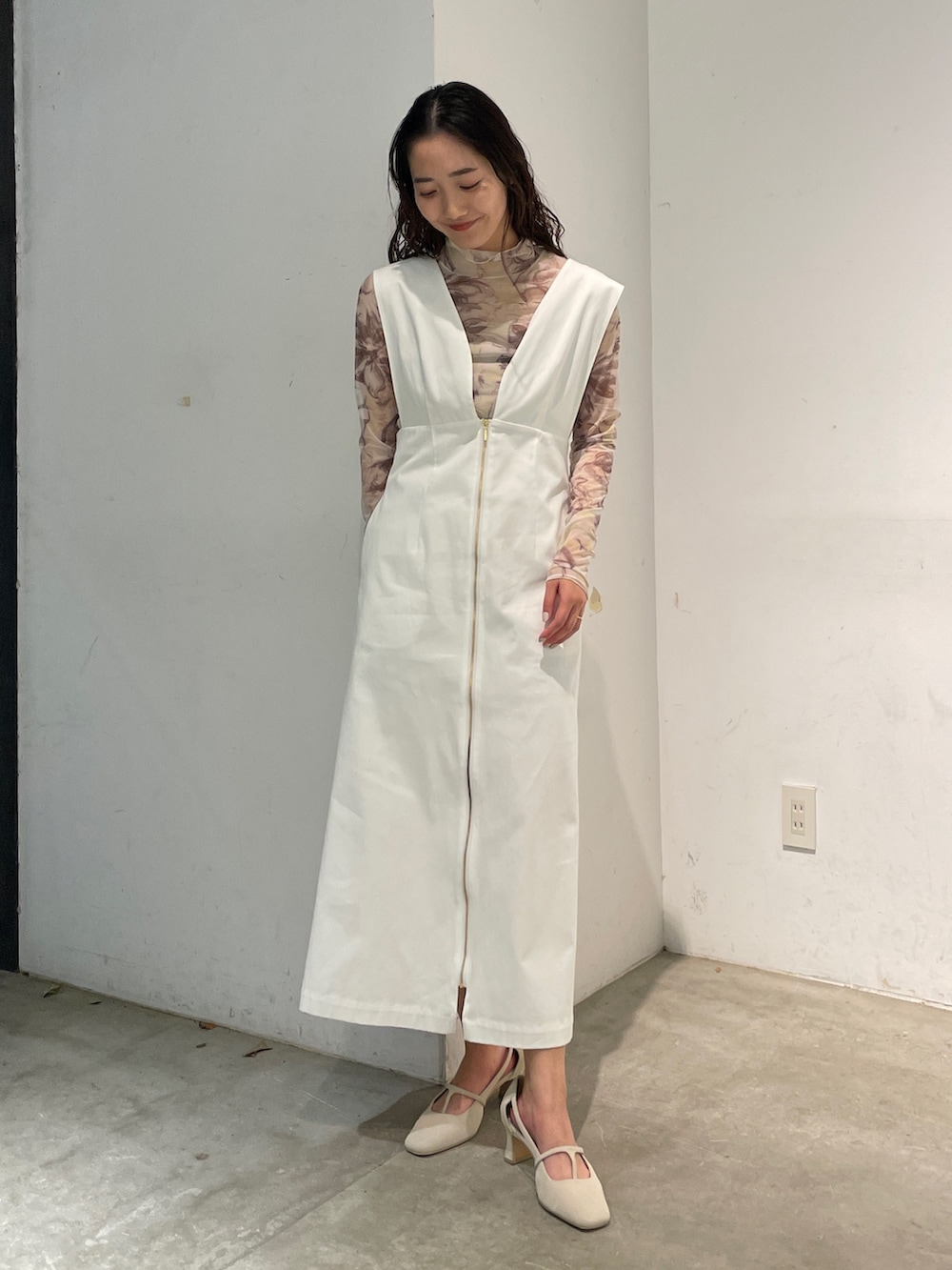 ホワイト系のパンプス、イエロー系のTシャツ/カットソー、ホワイト系のジャンパースカートを着用したレディースの冬コーディネートの2枚目の写真