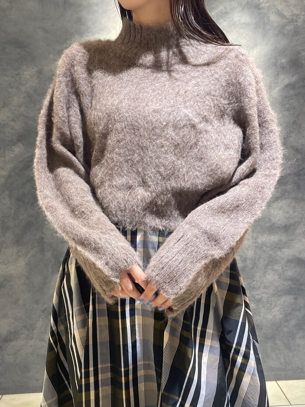 ブラウン系のニット/セーター、オレンジ系のスカート、ベージュ系のブーツを着用したレディースの秋コーディネートの8枚目の写真