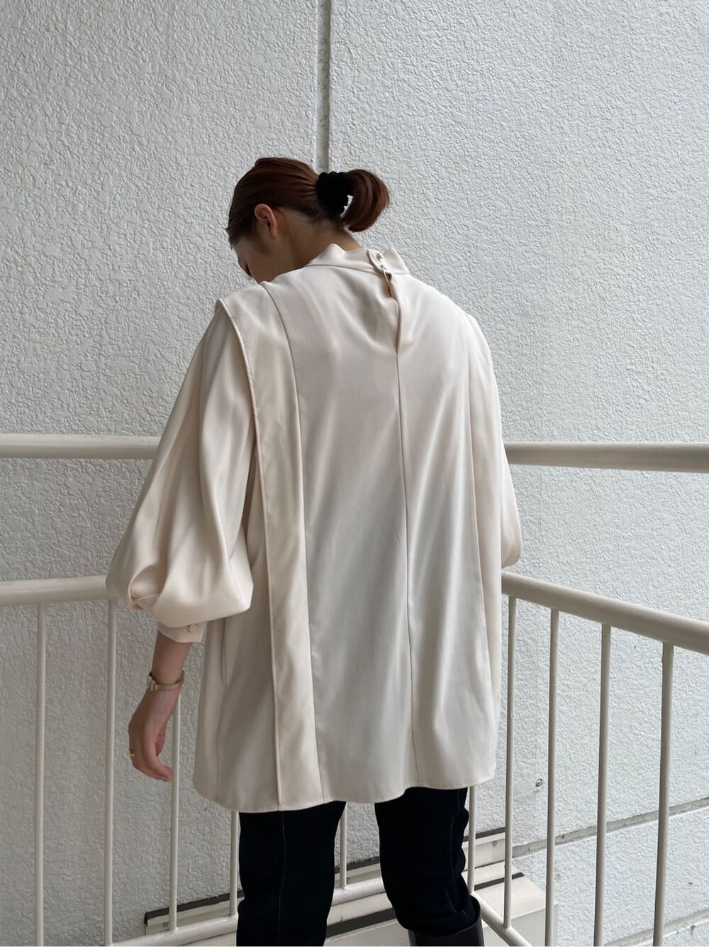 ブラック系のブーツ、ホワイト系のショルダーバッグ、ブルー系のデニムパンツを着用したレディースの秋コーディネートの6枚目の写真