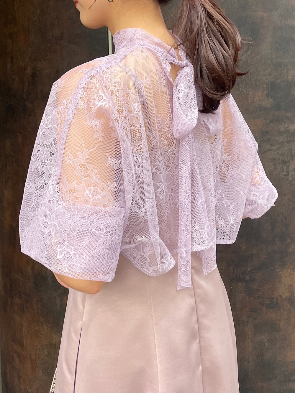 ベージュ系のパンプス、パープル系のドレス、ベージュ系のクラッチバッグを着用したレディースの冬コーディネートの5枚目の写真