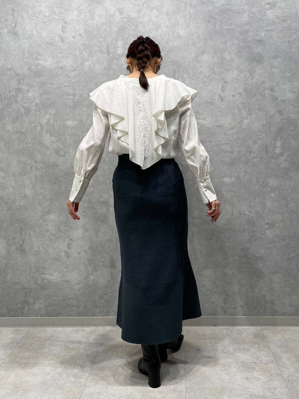 ホワイト系のカーディガン/ボレロ、ブラック系のブーツ、グリーン系のスカートを着用したレディースの冬コーディネートの7枚目の写真