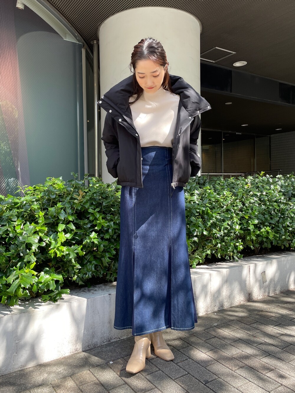 ベージュ系のブーツ、ブルー系のスカート、ホワイト系のニット/セーターを着用したレディースの秋コーディネートの2枚目の写真