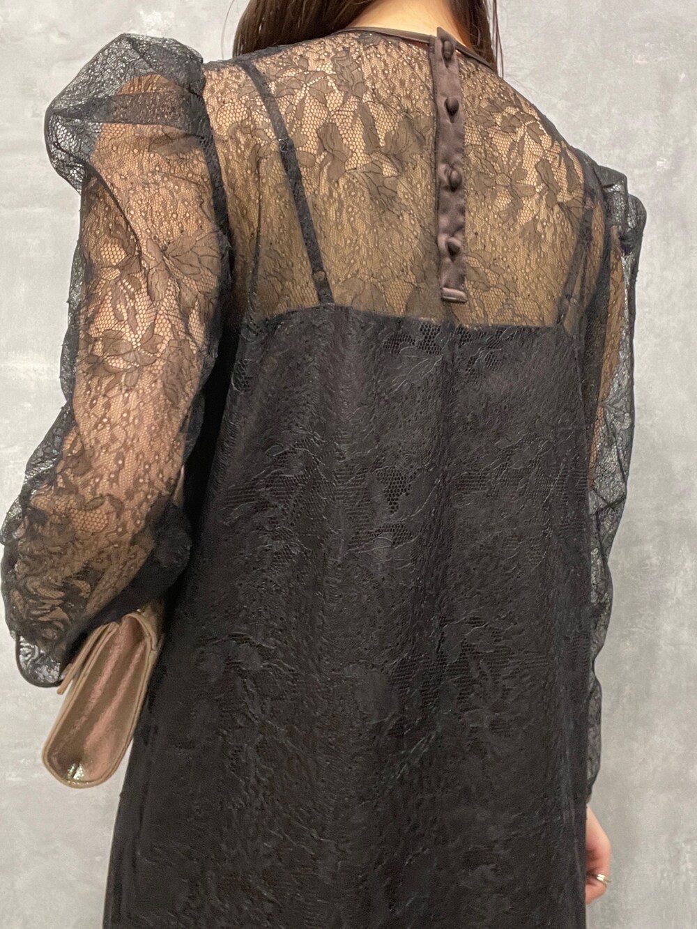 ゴールド系のパンプス、ゴールド系のハンドバッグ、ブラック系のドレスを着用したレディースの秋コーディネートの8枚目の写真