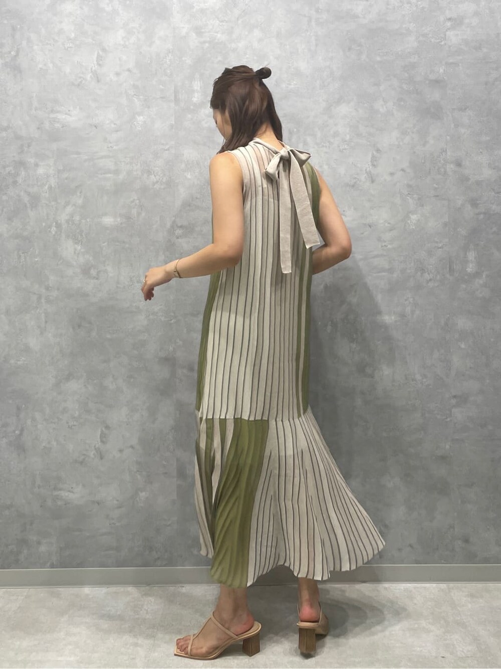 グリーン系のワンピース、ベージュ系のサンダルを着用したレディースの夏コーディネートの4枚目の写真