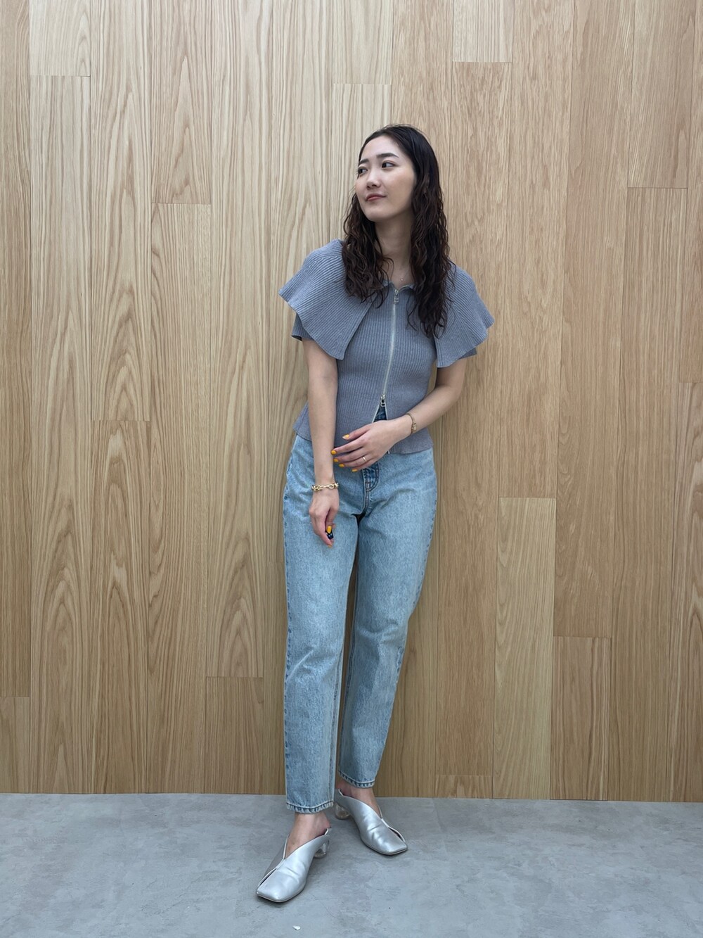 ブルー系のデニムパンツ、グレー系のニット/セーター、シルバー系のパンプスを着用したレディースの春コーディネートの3枚目の写真