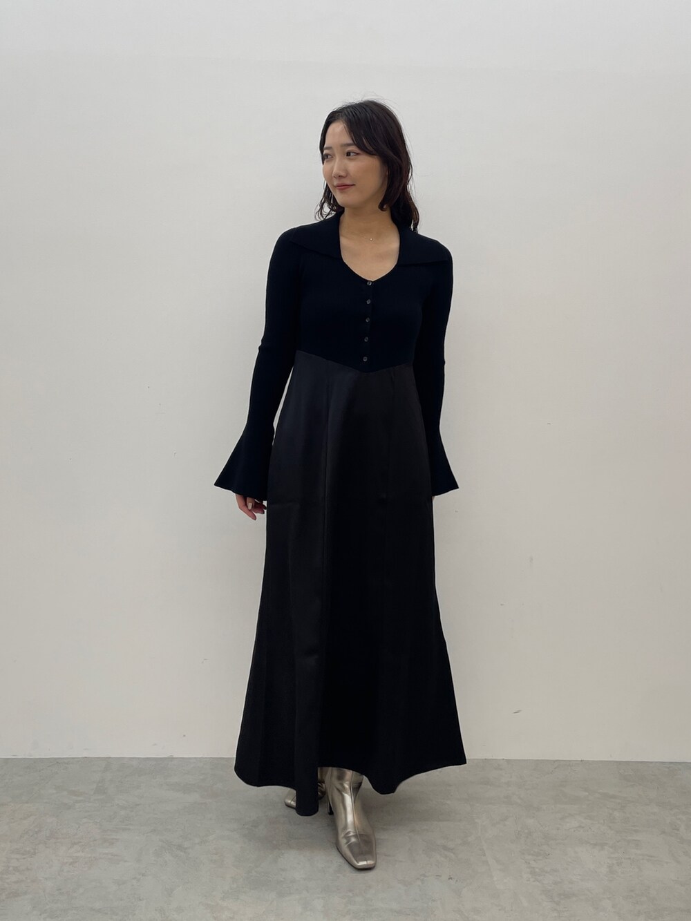 ブラック系のワンピース、シルバー系のブーツを着用したレディースの秋コーディネートの2枚目の写真