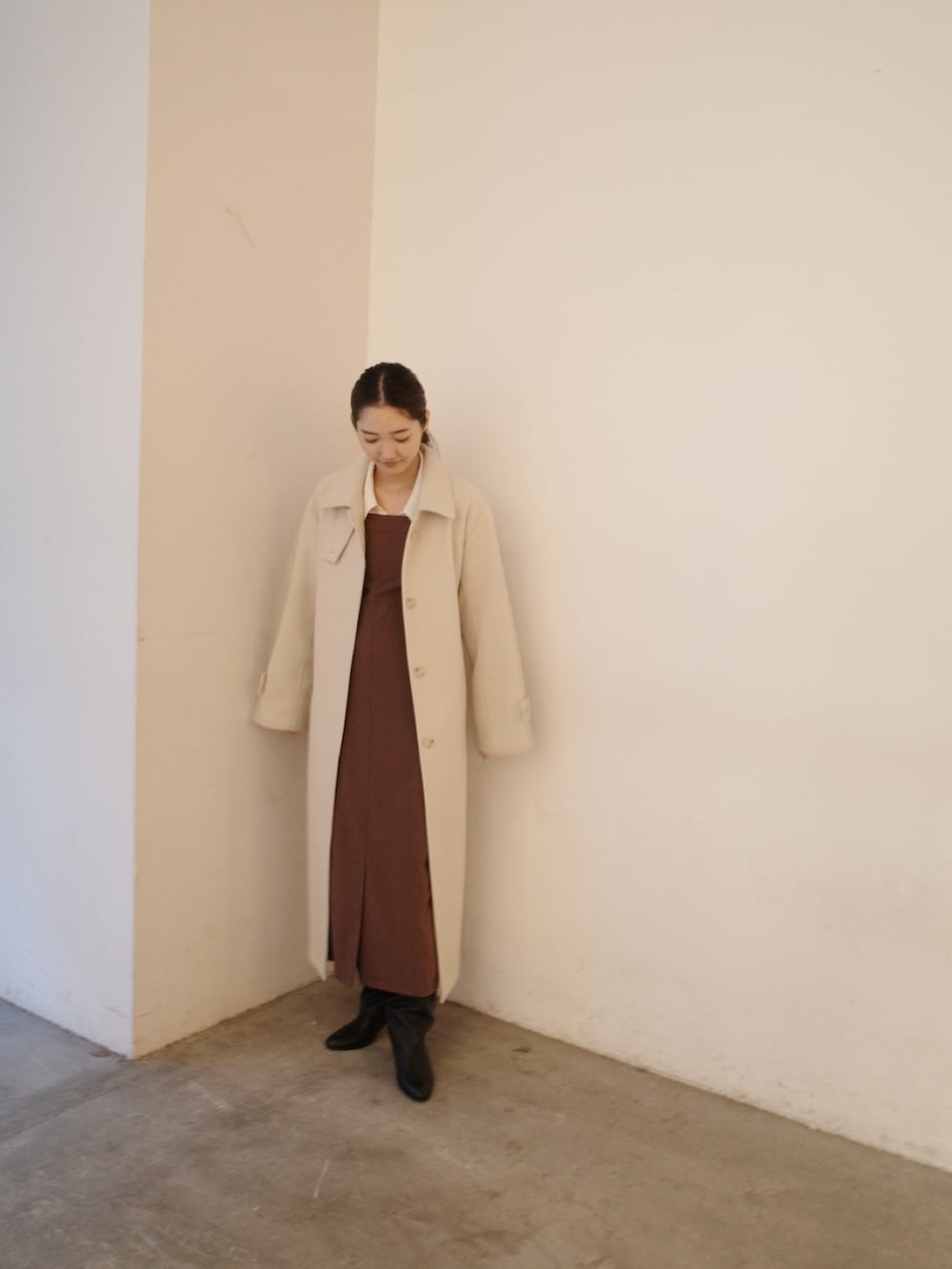 グレー系のステンカラーコート、ブラウン系のワンピースを着用したレディースの秋コーディネートの2枚目の写真