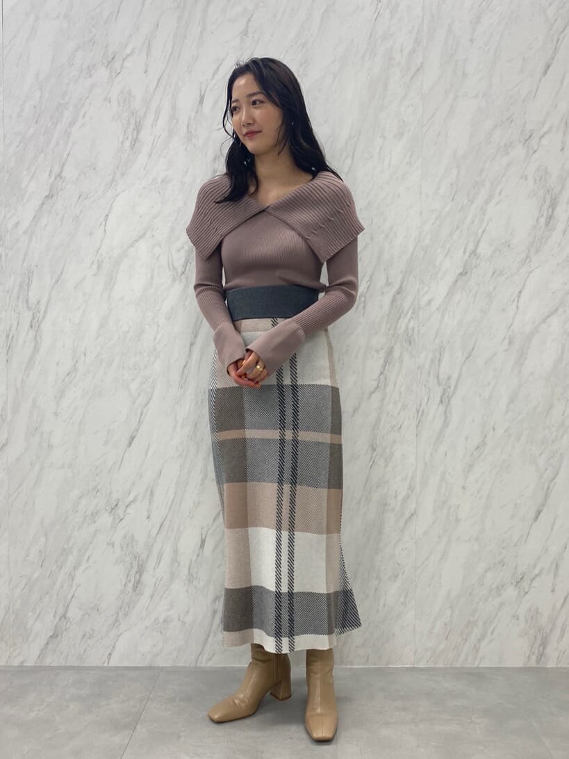 ベージュ系のブーツ、ベージュ系のスカート、ベージュ系のニット/セーターを着用したレディースの夏コーディネートの2枚目の写真