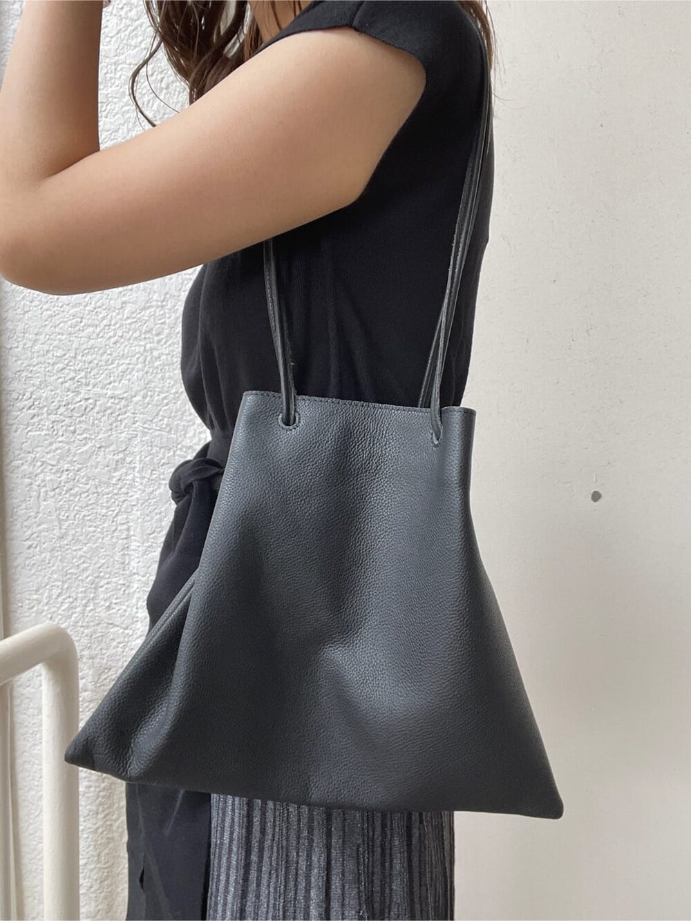ホワイト系のスニーカー、ブラック系のハンドバッグ、ブラック系のワンピースを着用したレディースの春コーディネートの8枚目の写真