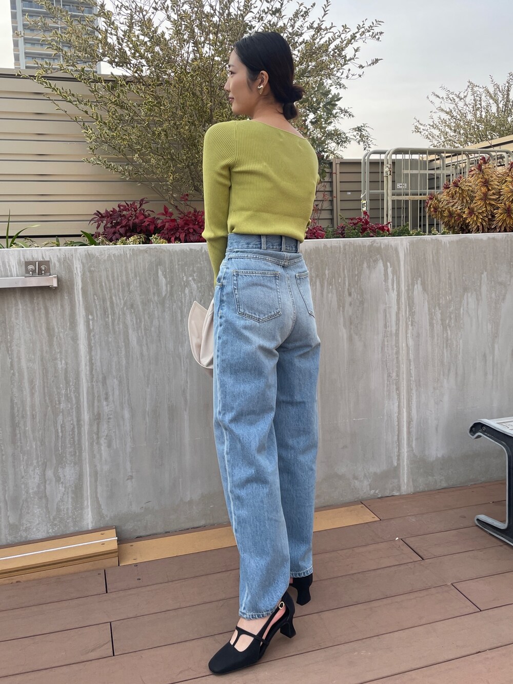 ブルー系のデニムパンツ、ホワイト系のトレンチコート、グリーン系のニット/セーターを着用したレディースの冬コーディネートの7枚目の写真