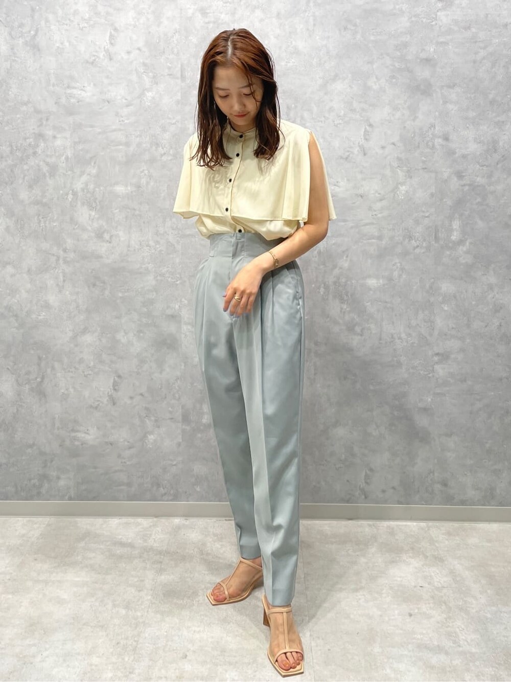 ブルー系のスラックス、ベージュ系のサンダル、ホワイト系のシャツ/ブラウスを着用したレディースの夏コーディネートの3枚目の写真