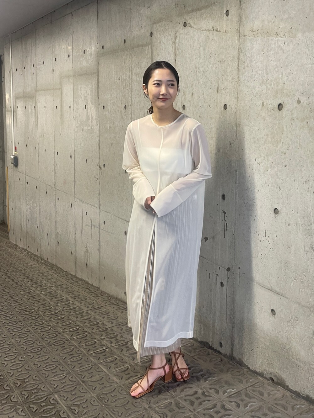 ホワイト系のTシャツ/カットソー、ベージュ系のスカート、ブラウン系のサンダルを着用したレディースの春コーディネートの5枚目の写真