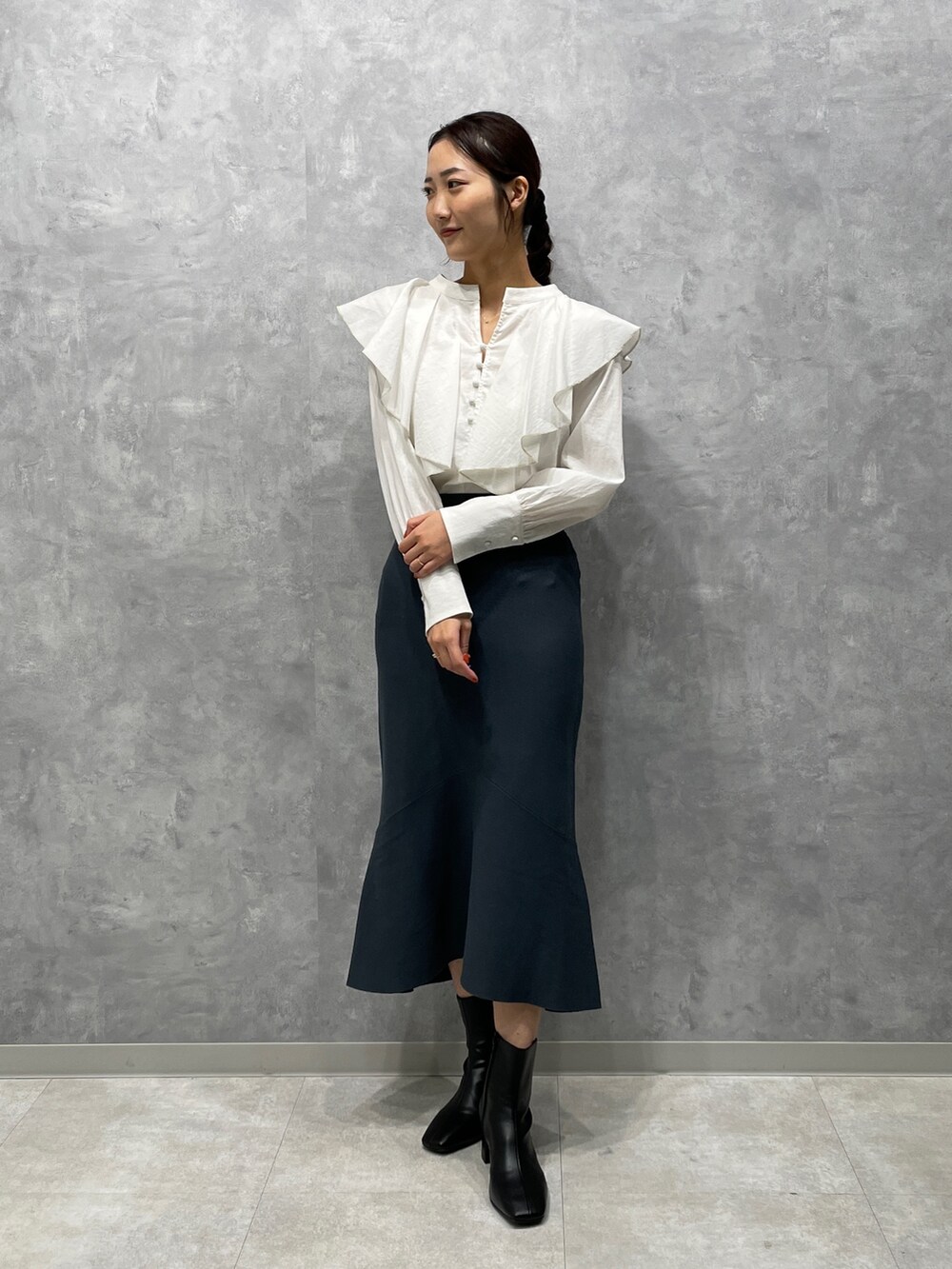 ホワイト系のカーディガン/ボレロ、ブラック系のブーツ、グリーン系のスカートを着用したレディースの冬コーディネートの6枚目の写真