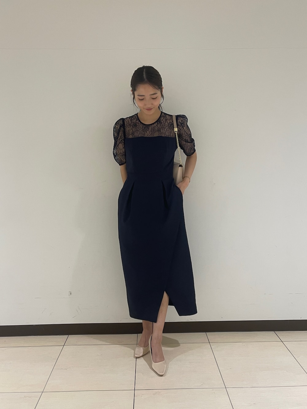 ゴールド系のクラッチバッグ、ベージュ系のパンプス、ブルー系のドレスを着用したレディースの春コーディネートの5枚目の写真