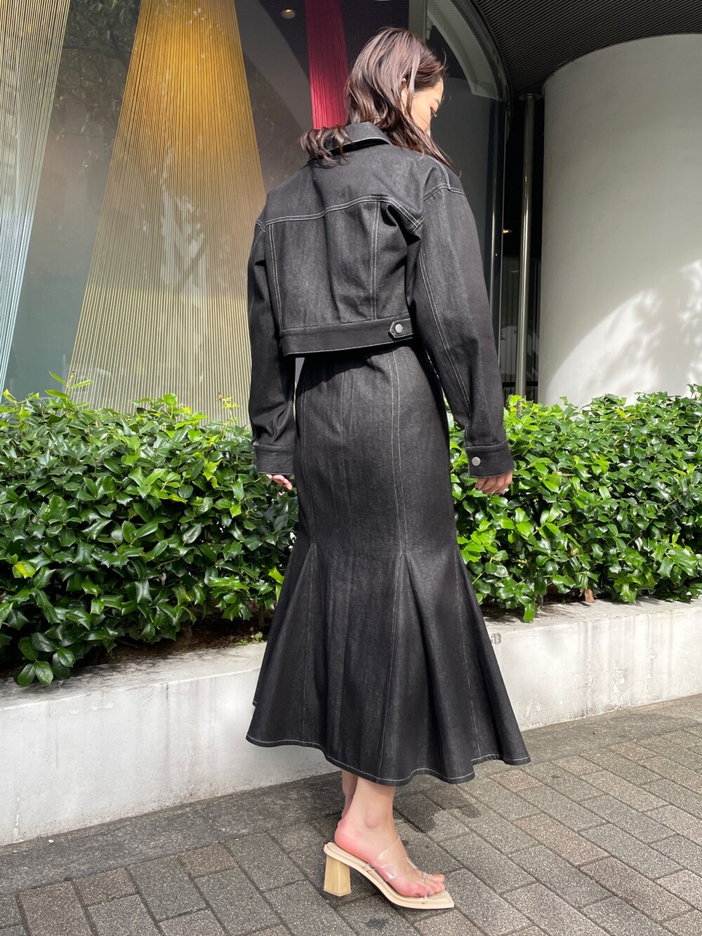 ブラック系のデニムジャケット、ブラック系のワンピース、その他のサンダルを着用したレディースの冬コーディネートの3枚目の写真