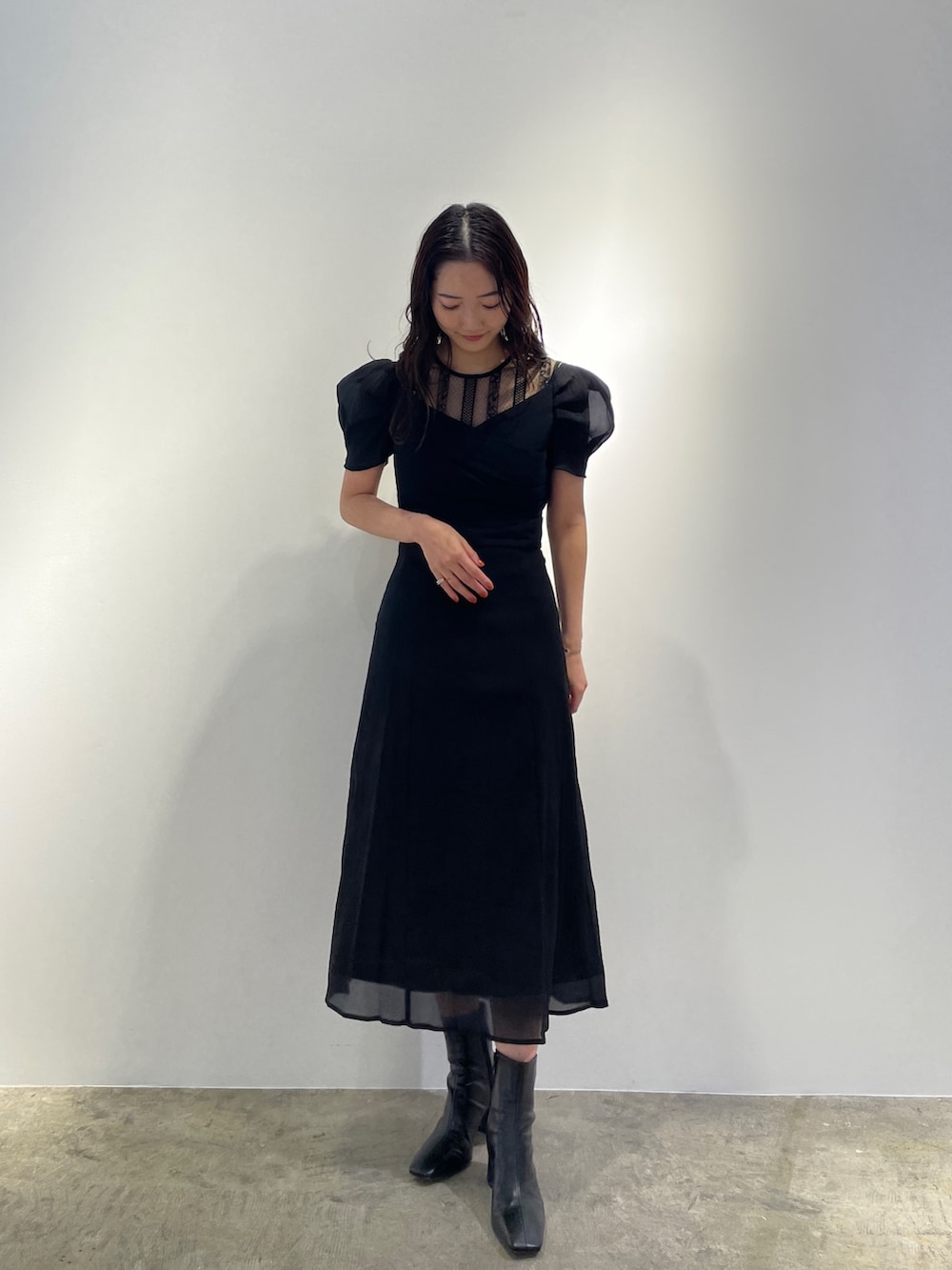 ブラック系のドレス、ブラック系のブーツを着用したレディースの冬コーディネートの2枚目の写真