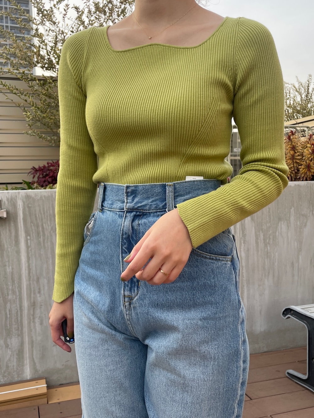 ブルー系のデニムパンツ、ホワイト系のトレンチコート、グリーン系のニット/セーターを着用したレディースの冬コーディネートの8枚目の写真