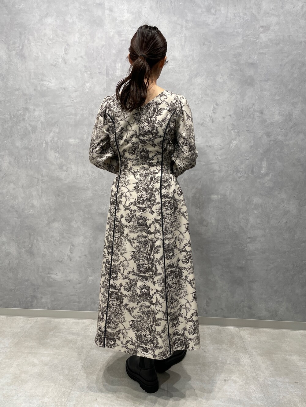 グレー系のカーディガン/ボレロ、ホワイト系のワンピース、ブラック系のブーツを着用したレディースの冬コーディネートの8枚目の写真