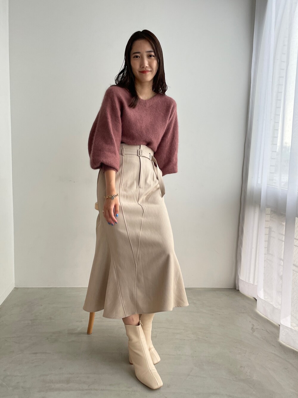 ホワイト系のブーツ、ベージュ系のスカート、ピンク系のニット/セーターを着用したレディースの夏コーディネートの4枚目の写真