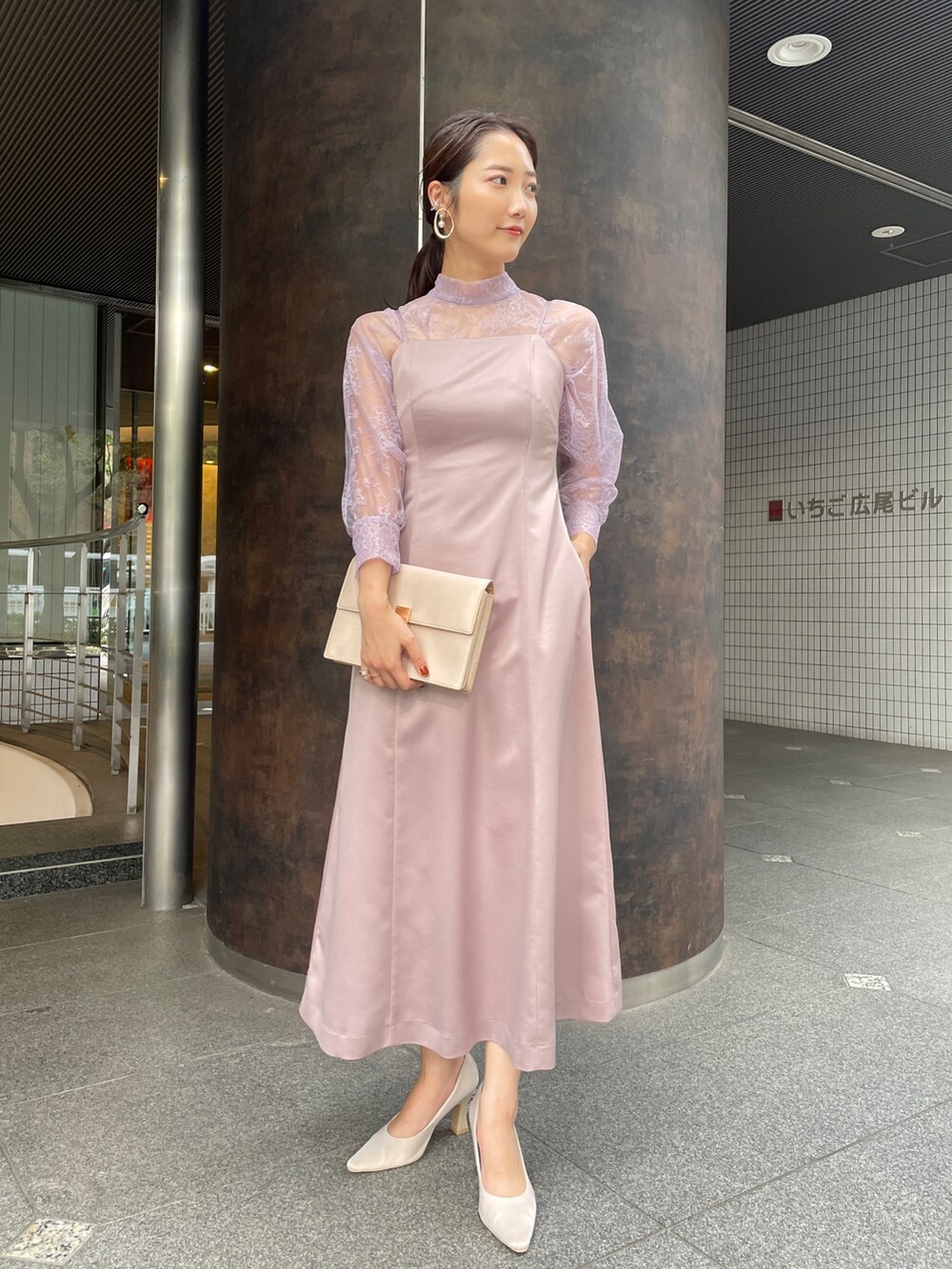 ベージュ系のパンプス、パープル系のドレス、ベージュ系のクラッチバッグを着用したレディースの冬コーディネートの6枚目の写真