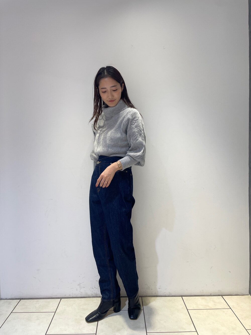 ブラック系のブーツ、ブルー系のデニムパンツ、グレー系のニット/セーターを着用したレディースの秋コーディネートの3枚目の写真