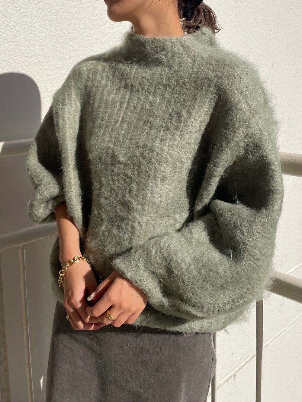 ベージュ系のその他シューズ、グリーン系のニット/セーター、グレー系のスカートを着用したレディースの秋コーディネートの5枚目の写真