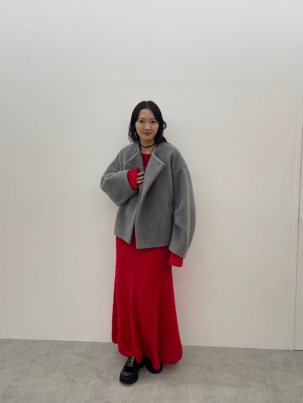 グレー系のブルゾン、レッド系のワンピース、ブラック系のローファーを着用したレディースの秋コーディネートの2枚目の写真