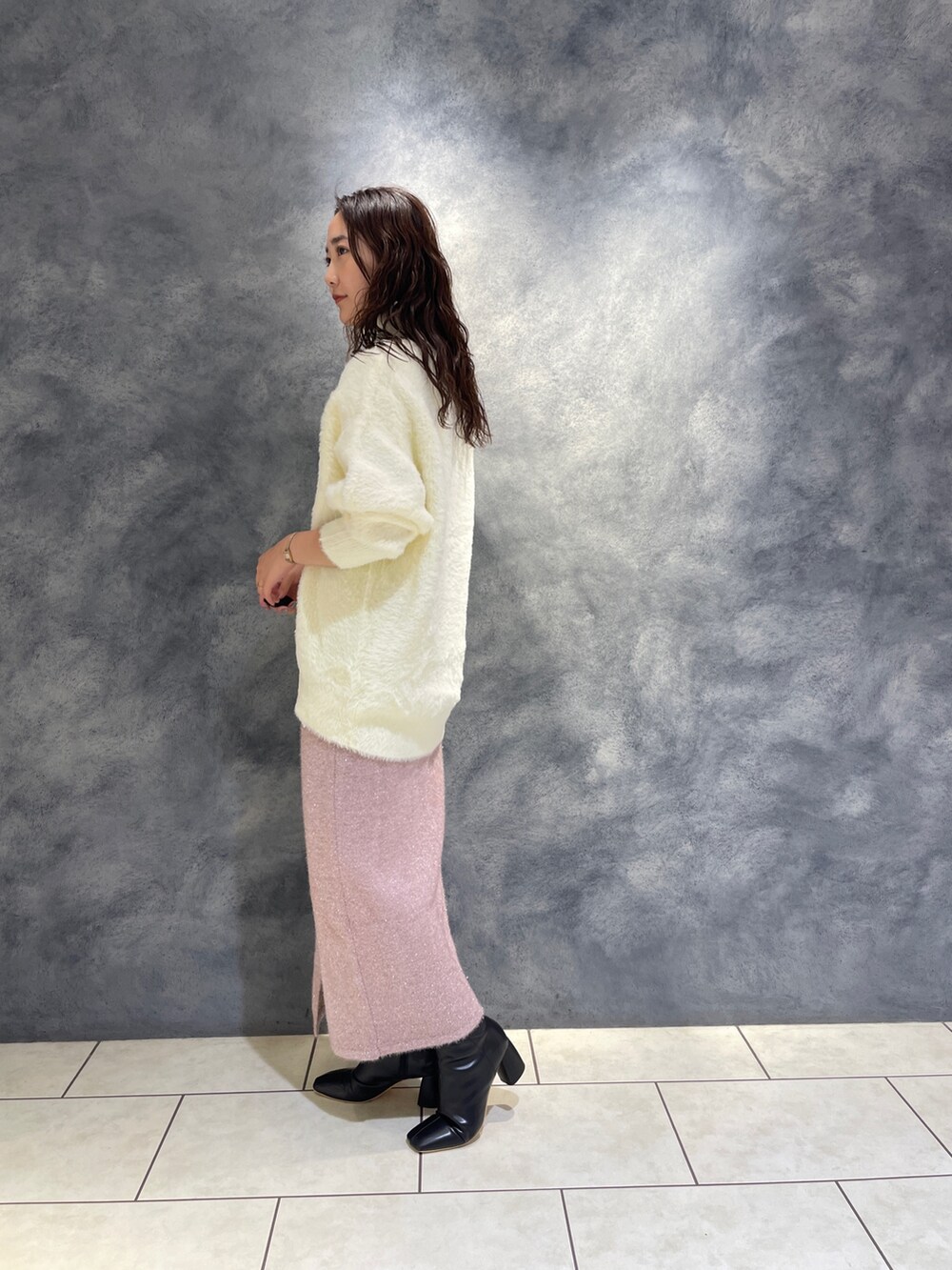 ホワイト系のニット/セーター、ピンク系のスカート、ブラック系のブーツを着用したレディースの秋コーディネートの5枚目の写真