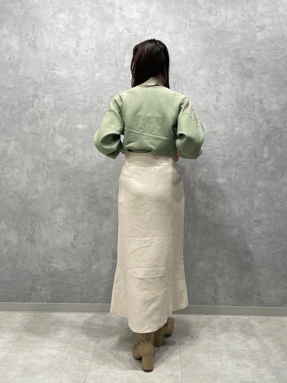 ベージュ系のブーツ、グリーン系のニット/セーター、ベージュ系のその他アウターを着用したレディースの冬コーディネートの7枚目の写真