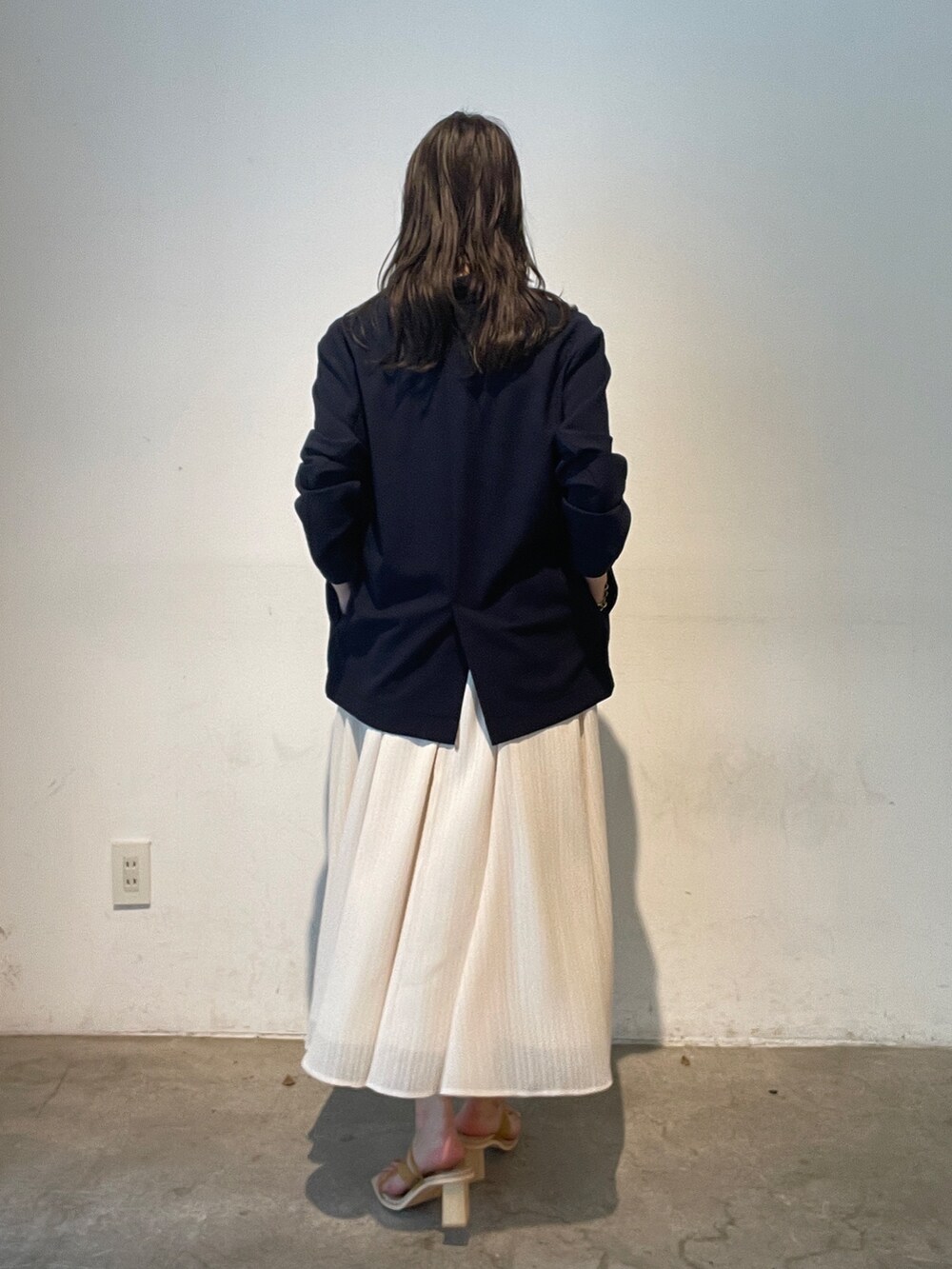 イエロー系のサンダル、ブルー系のテーラードジャケット、ホワイト系のワンピースを着用したレディースの夏コーディネートの4枚目の写真