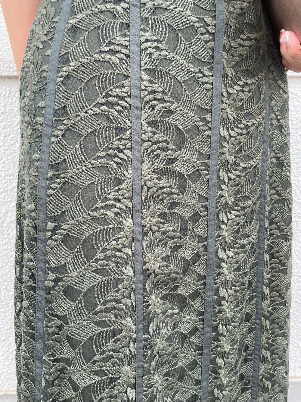 グリーン系のドレス、ベージュ系のパンプス、ブラウン系のクラッチバッグを着用したレディースの夏コーディネートの9枚目の写真