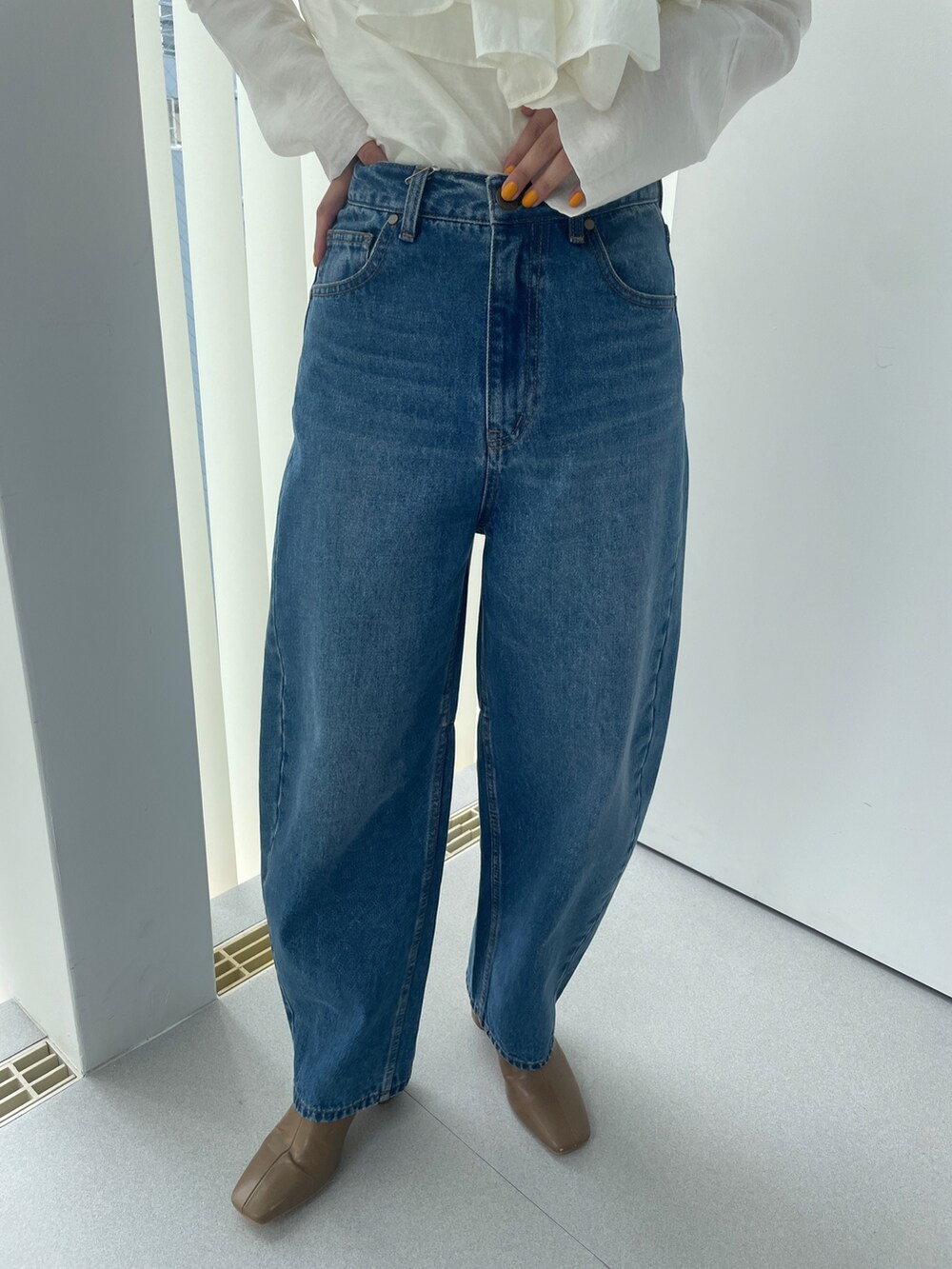 ベージュ系のブーツ、ホワイト系のシャツ/ブラウス、ブルー系のデニムパンツを着用したレディースの夏コーディネートの9枚目の写真