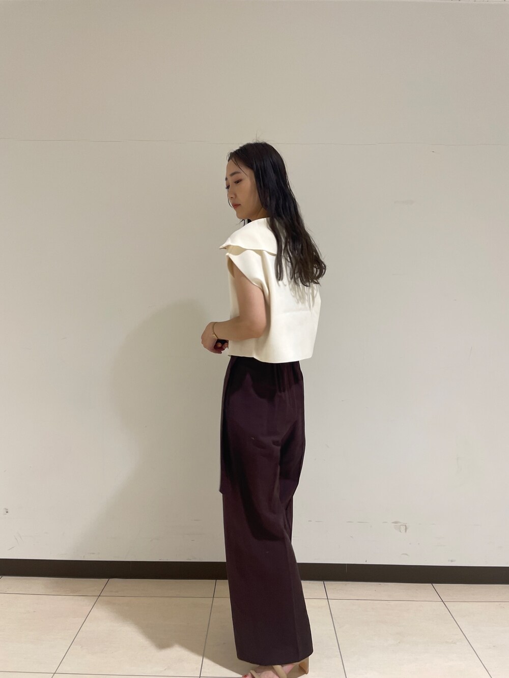 ブラウン系のその他パンツ、ホワイト系のニット/セーター、ベージュ系のサンダルを着用したレディースの春コーディネートの5枚目の写真