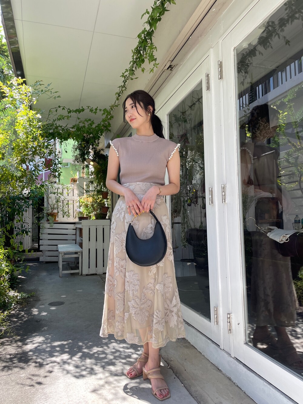 ベージュ系のサンダル、ベージュ系のニット/セーター、ベージュ系のスカートを着用したレディースの春コーディネートの6枚目の写真