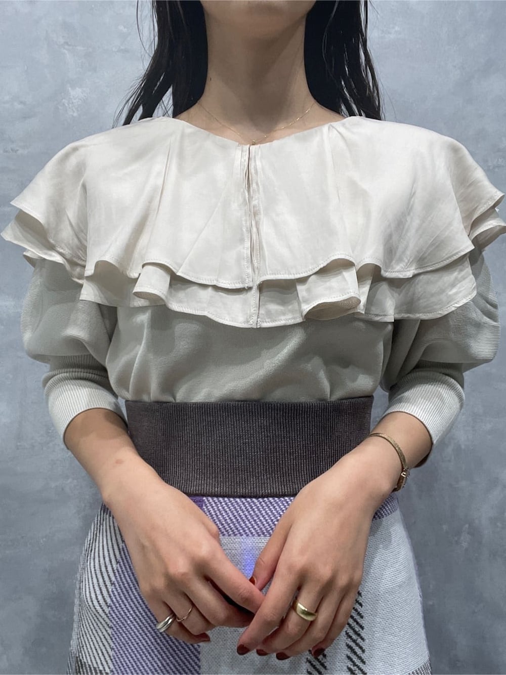 ベージュ系のブーツ、ホワイト系のニット/セーター、パープル系のスカートを着用したレディースの秋コーディネートの7枚目の写真