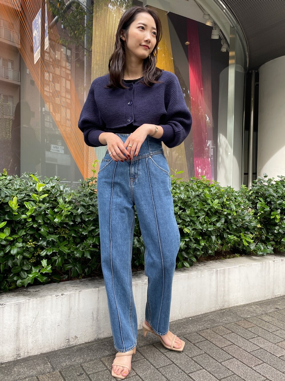 ベージュ系のサンダル、ブルー系のデニムパンツ、ブラック系のニット/セーターを着用したレディースの冬コーディネートの3枚目の写真