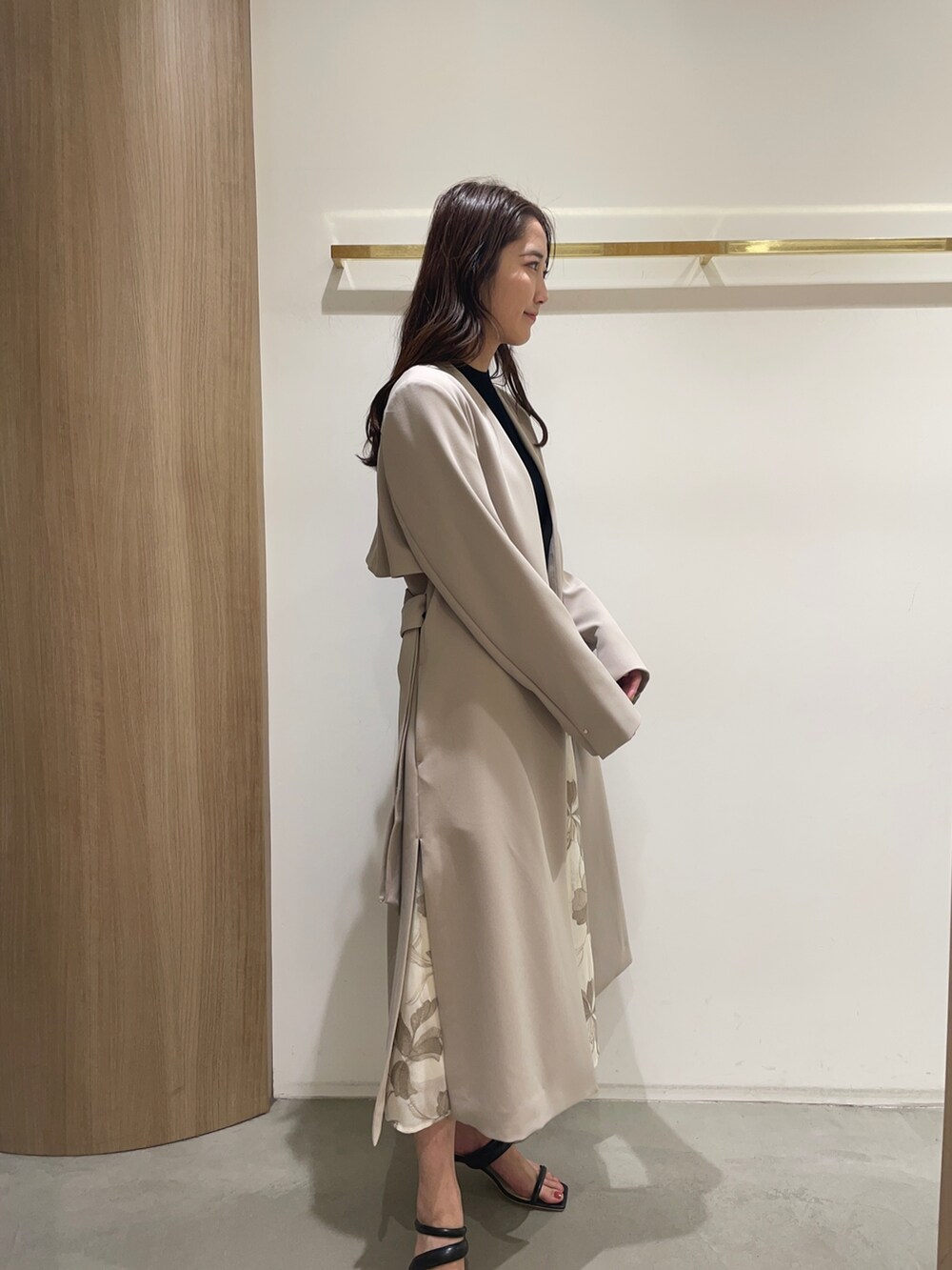 ブラック系のニット/セーター、ブラック系のサンダル、ベージュ系のスカートを着用したレディースの春コーディネートの5枚目の写真