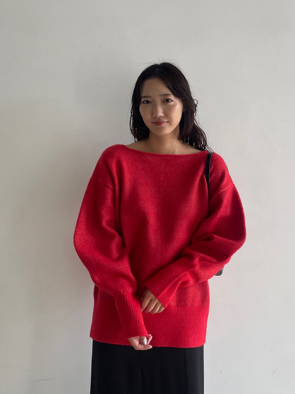 ブラック系のブーツ、ブラック系のスカート、レッド系のニット/セーターを着用したレディースの秋コーディネートの7枚目の写真