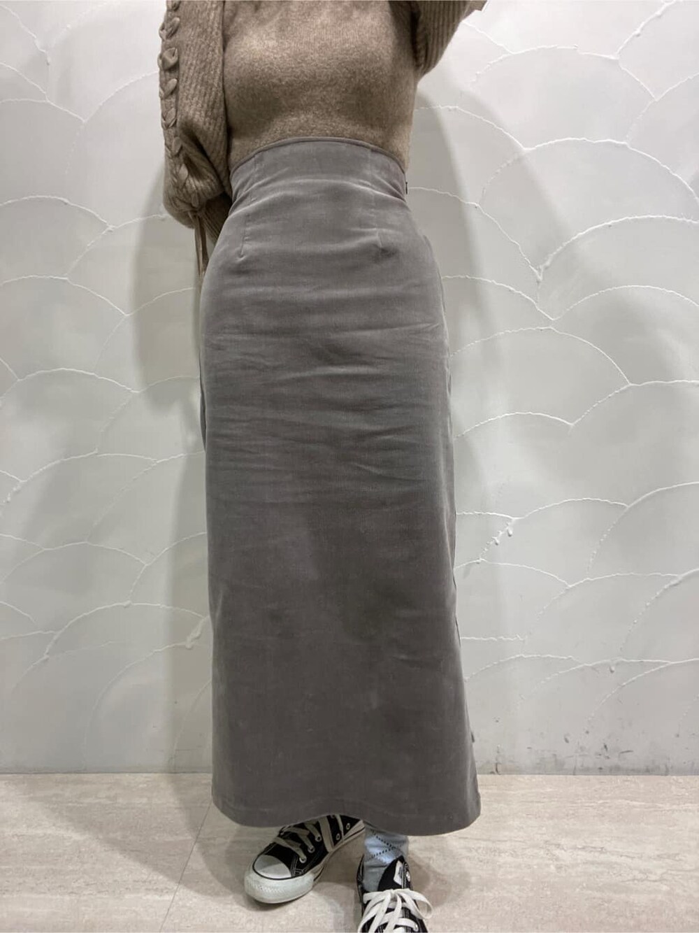 グレー系のスカート、ベージュ系のニット/セーターを着用したレディースの冬コーディネートの6枚目の写真