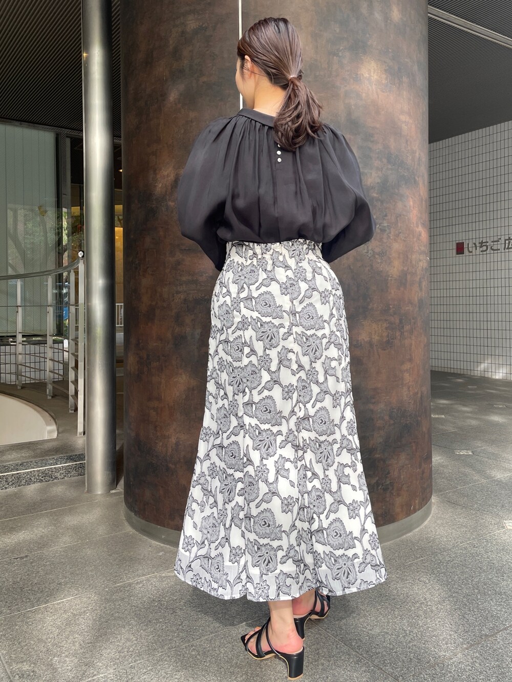 ベージュ系のサンダル、ブラック系のスカート、ブラック系のシャツ/ブラウスを着用したレディースの冬コーディネートの5枚目の写真