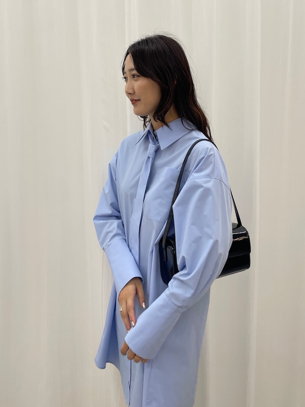 ブルー系のシャツワンピース、ブラック系のショルダーバッグを着用したレディースの秋コーディネートの8枚目の写真