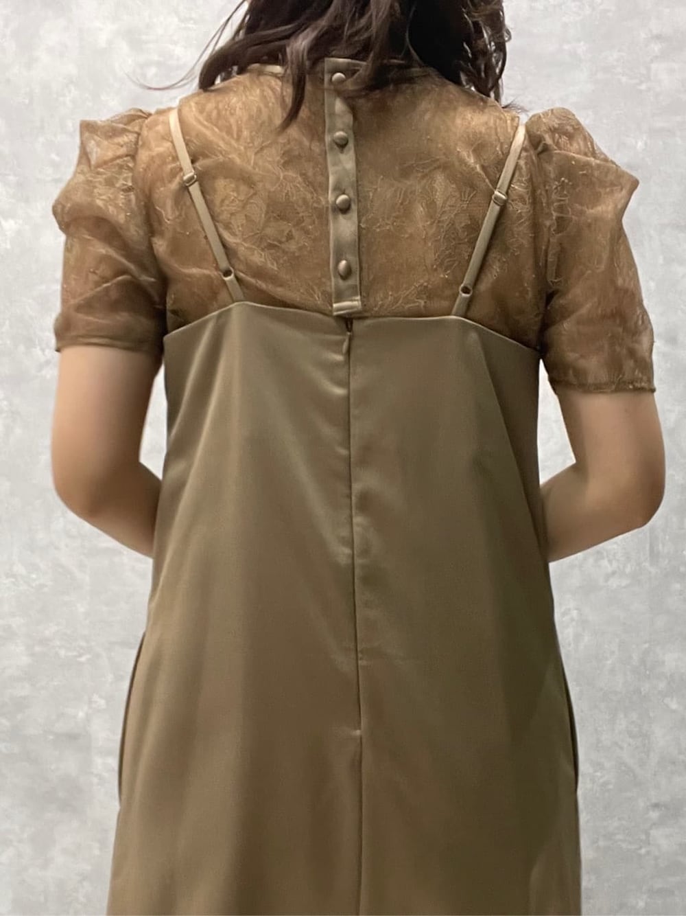 ゴールド系のクラッチバッグ、ベージュ系のパンプス、ベージュ系のドレスを着用したレディースの春コーディネートの7枚目の写真
