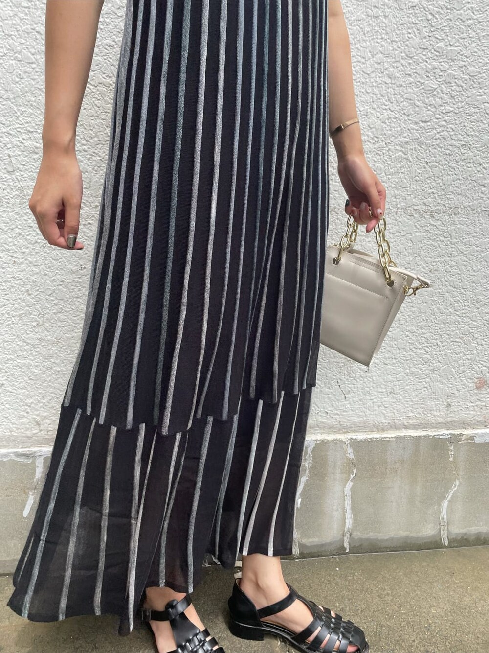 ブラック系のワンピース、ホワイト系のショルダーバッグを着用したレディースの夏コーディネートの7枚目の写真