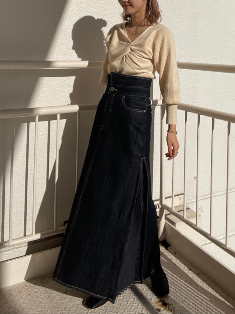 ブラック系のその他シューズ、ブルー系のデニムスカート、ホワイト系のニット/セーターを着用したレディースの冬コーディネートの4枚目の写真