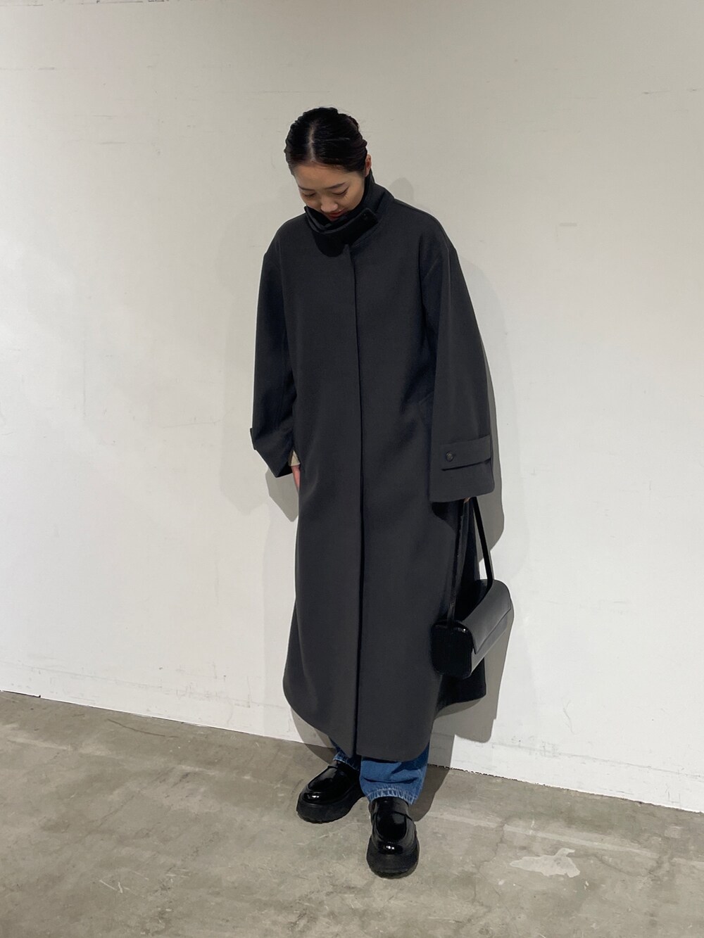 ブルー系のデニムパンツ、グレー系のステンカラーコート、ブラック系のローファーを着用したレディースの夏コーディネートの2枚目の写真