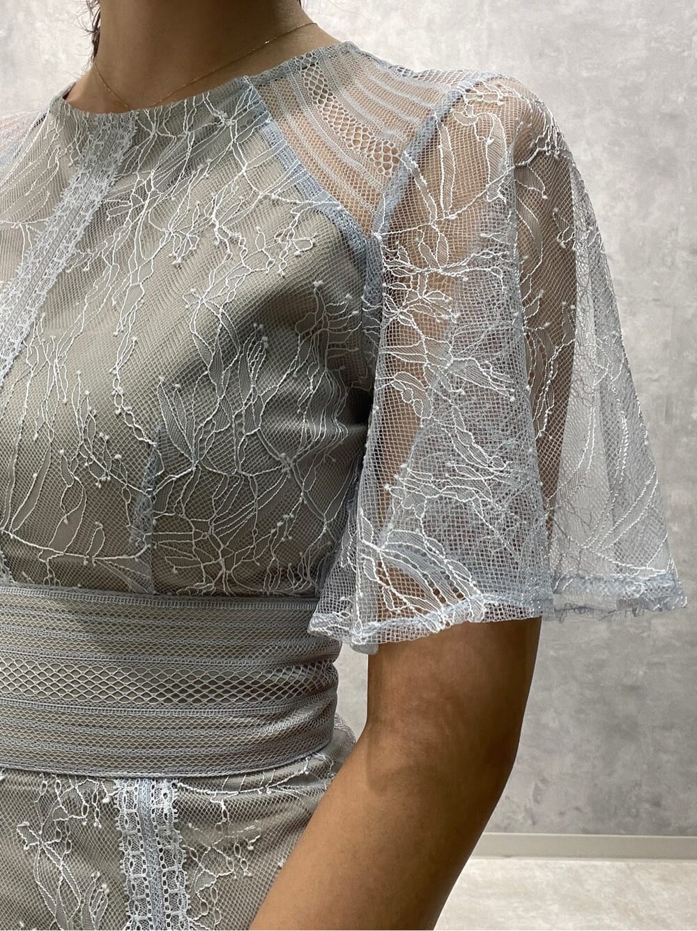 ゴールド系のクラッチバッグ、ベージュ系のパンプス、ブルー系のドレスを着用したレディースの春コーディネートの8枚目の写真