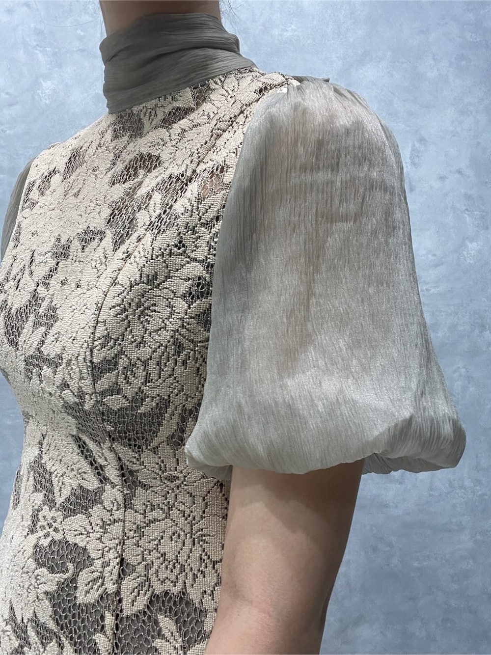 ベージュ系のドレス、シルバー系のパンプス、シルバー系のクラッチバッグを着用したレディースの夏コーディネートの6枚目の写真