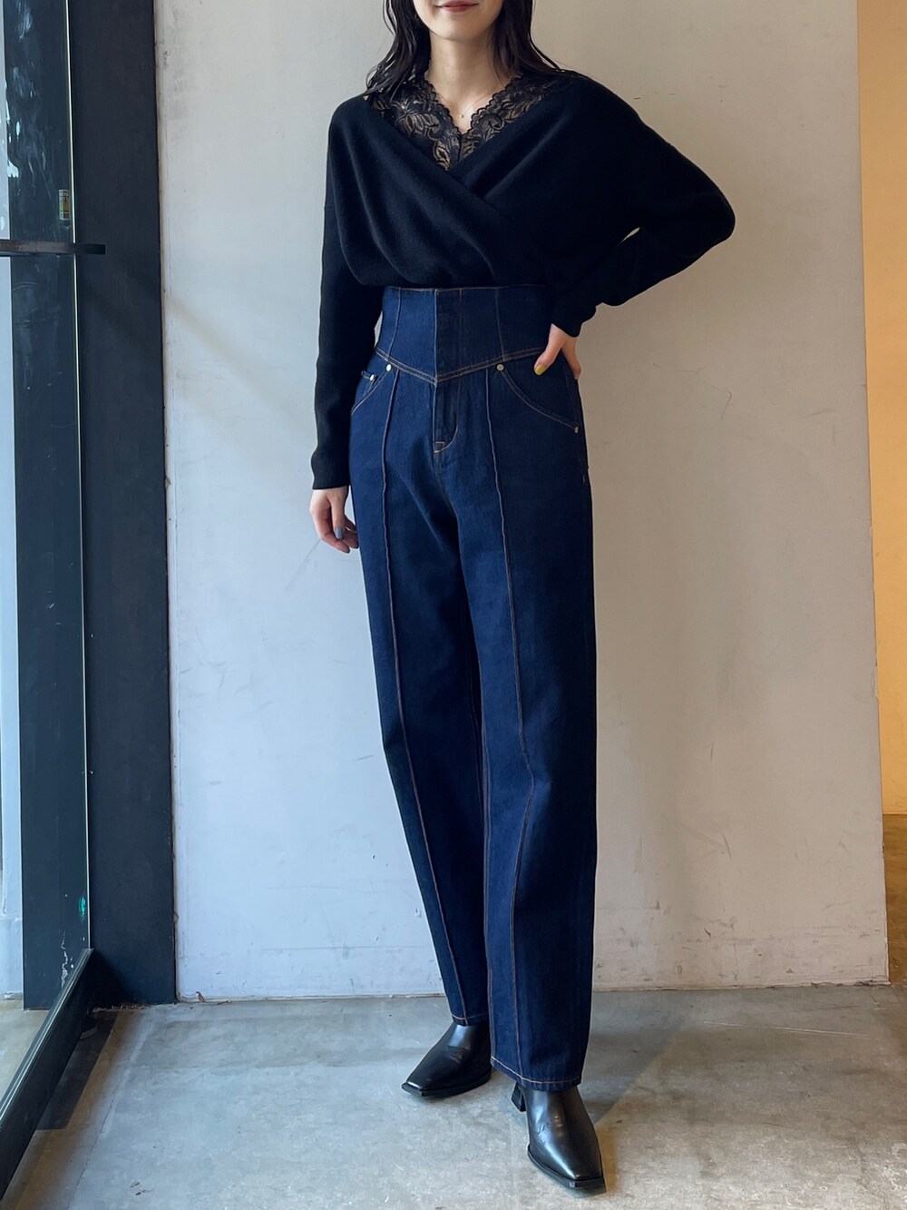 ブラック系のブーツ、ブルー系のデニムパンツ、ブラック系のニット/セーターを着用したレディースの冬コーディネートの2枚目の写真