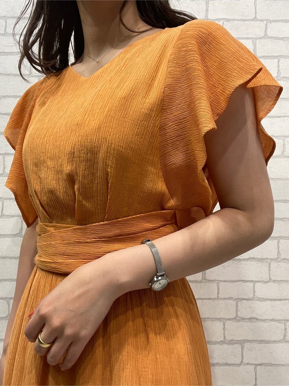 オレンジ系のワンピース、ホワイト系のサンダルを着用したレディースの春コーディネートの6枚目の写真