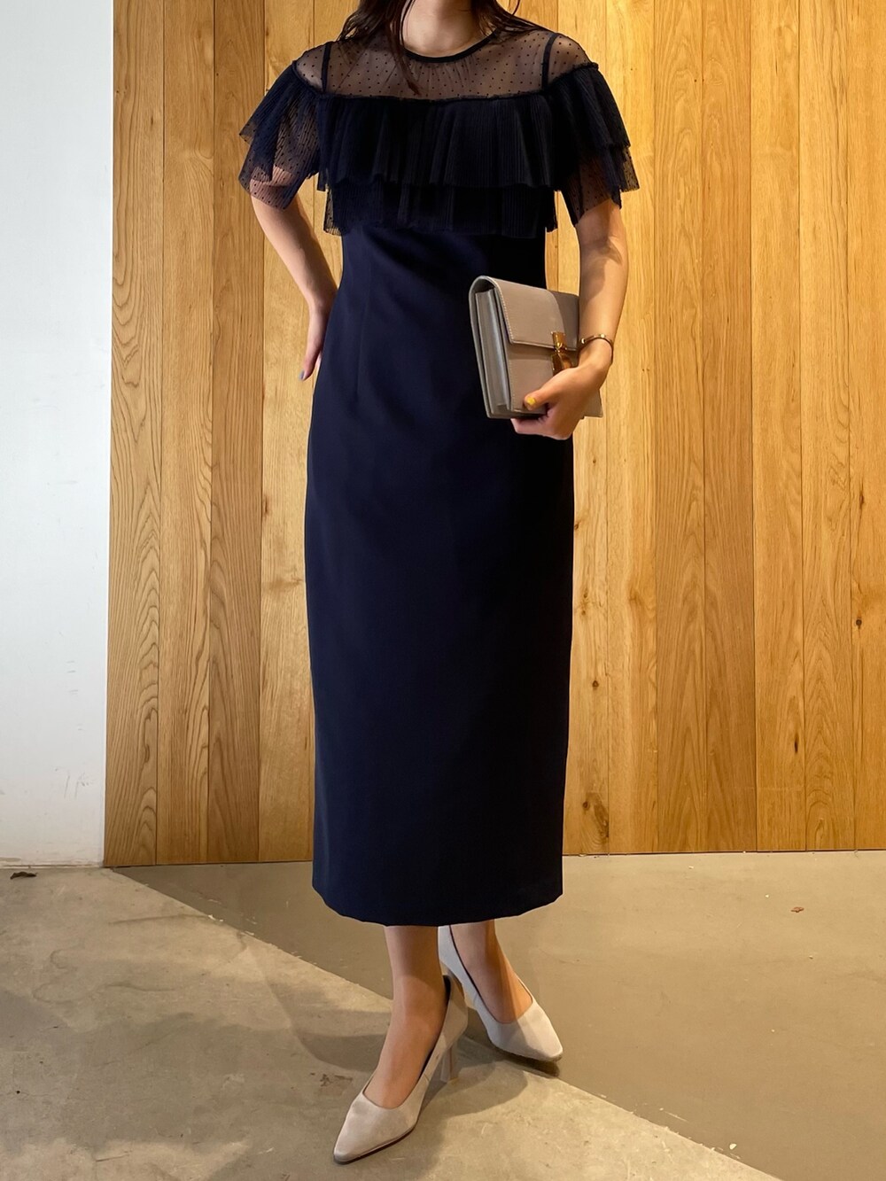 グレー系のパンプス、グレー系のクラッチバッグ、ブルー系のドレスを着用したレディースの冬コーディネートの6枚目の写真